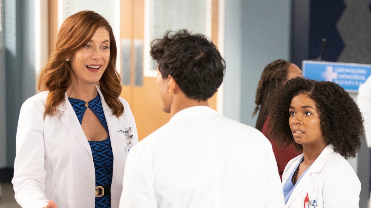 Kate Walsjh in a white lab coat and navy dress as Addison Montgomery on "Grey's Anatomy" in season 19