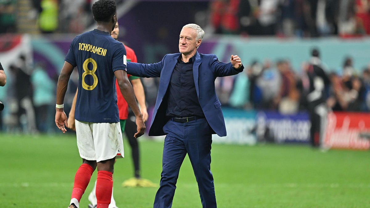 Didier Deschamps goes to hug one of his players