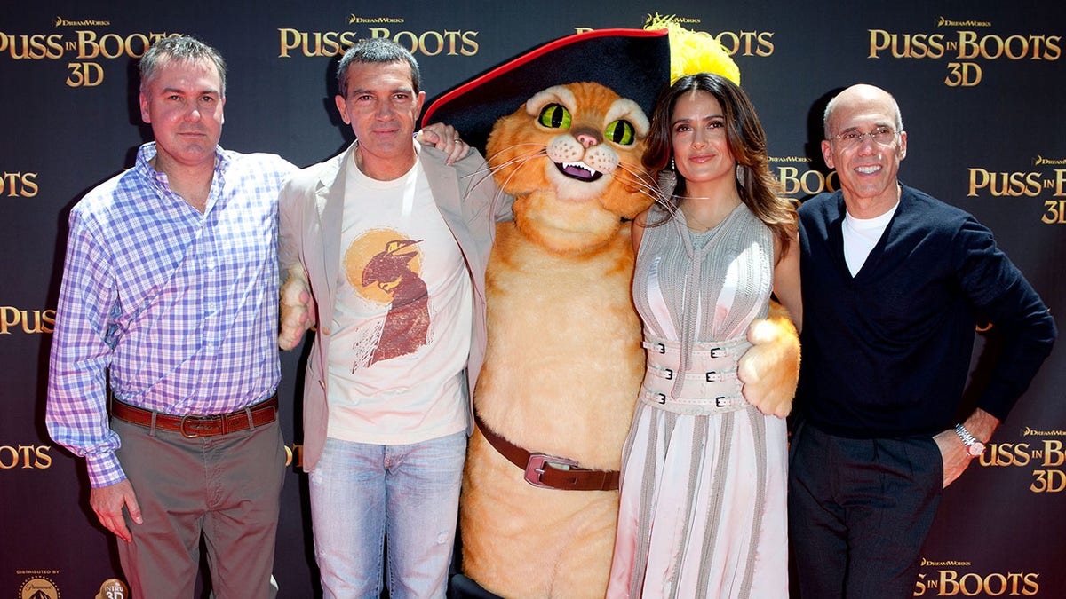 Antonio Banderas and Salma Hayek taking photos with the Puss in Boots character
