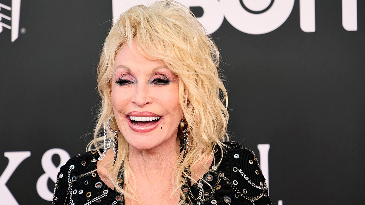 Dolly Parton in a jeweled black dress on the carpet for The Rock & Roll Hall of Fame