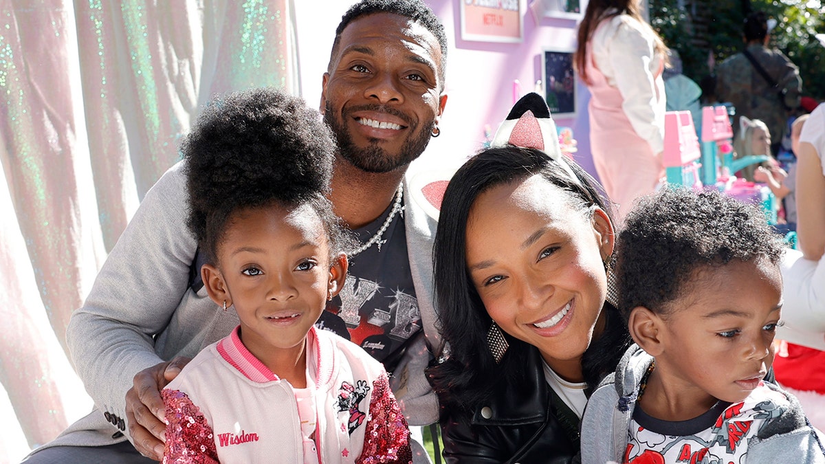Kel Mitchell smiling with his wife and two children