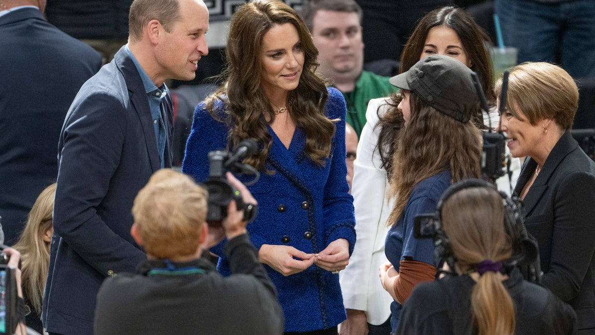 Kate Middleton and Prince William speak with 15-year-old climate change activist Ollie Perrault courtside at the Celtics game