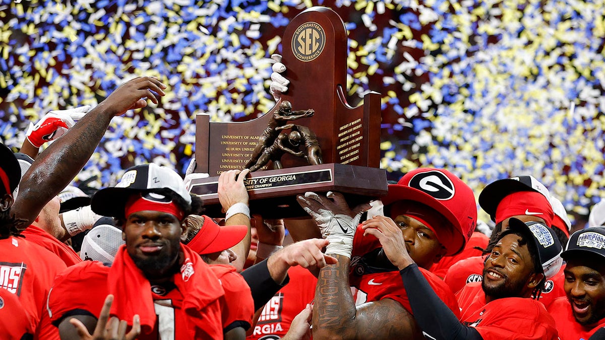 The Georgia Bulldogs hold the SEC championship trophy