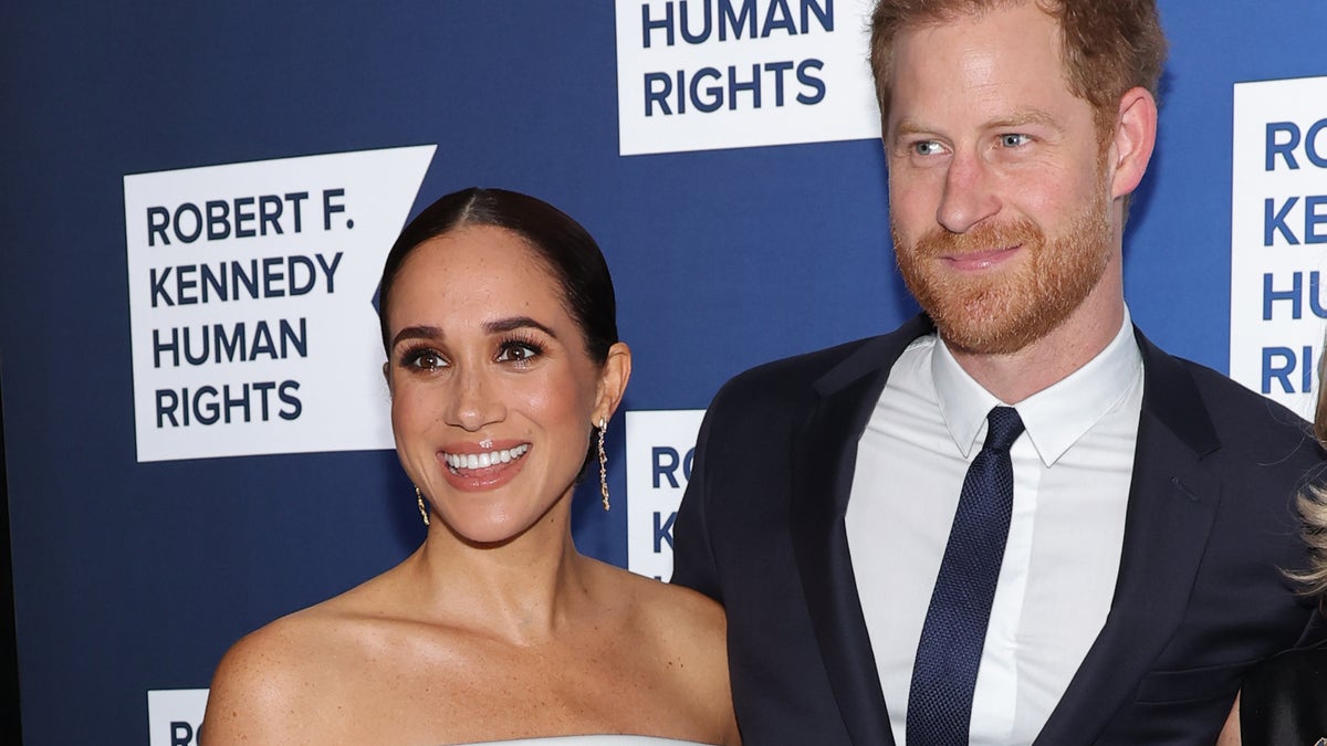 Meghan Markle smiles next to husband Prince Harry on red carpet