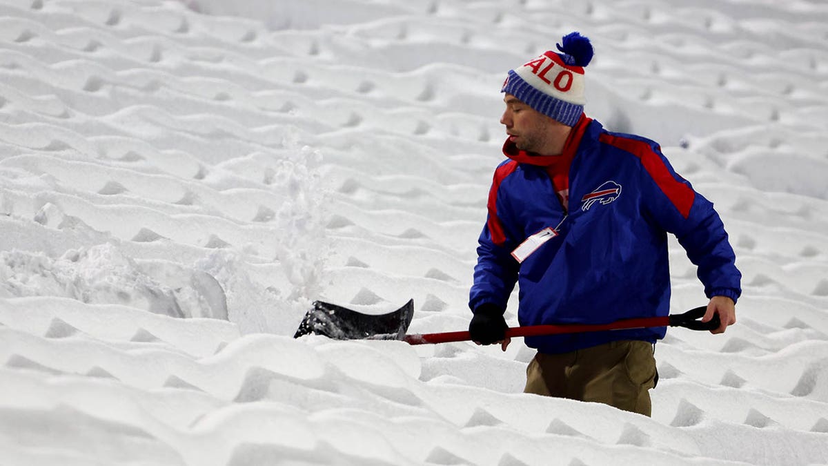 A stadium worker clears the Bills stadium of snow ahead a game against Miami
