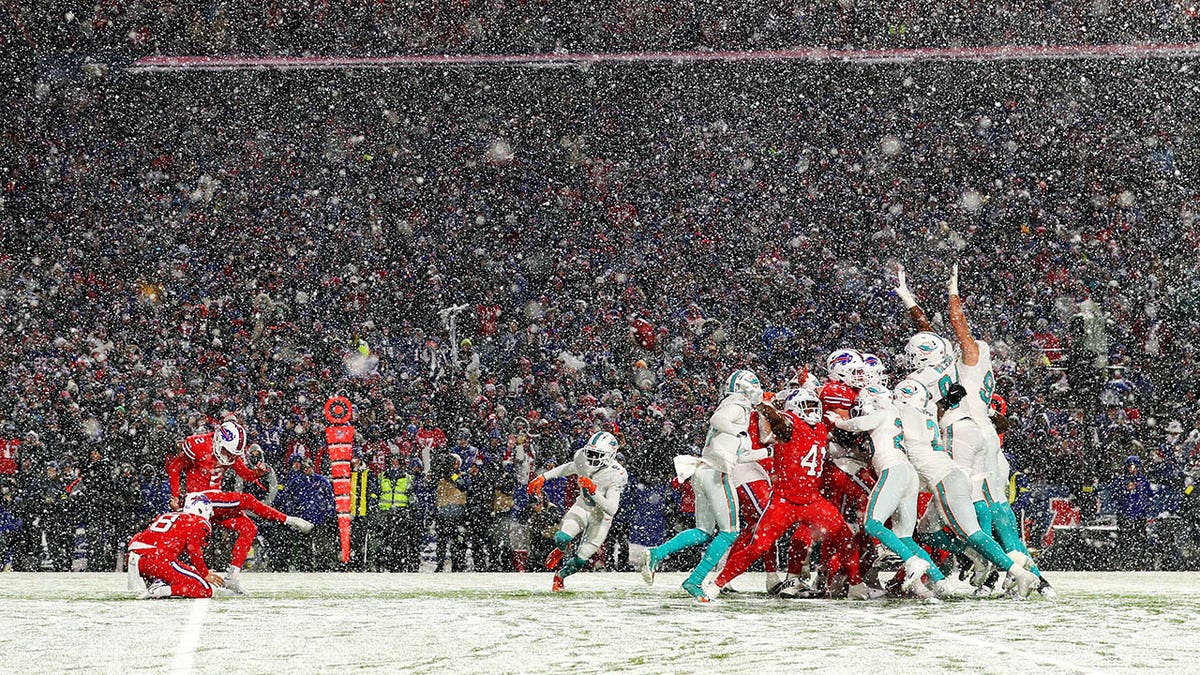 Bills and Dolphins players play in the snow at Buffalo's stadium