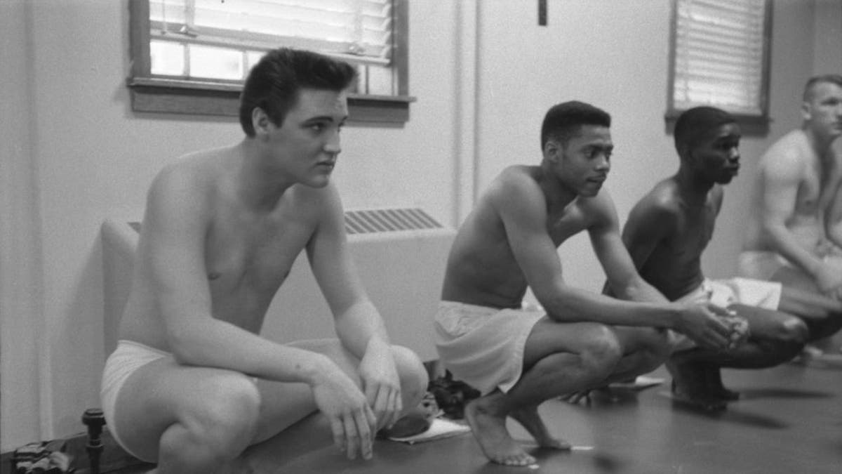 Elvis Presley squats while waiting for exams in the Army