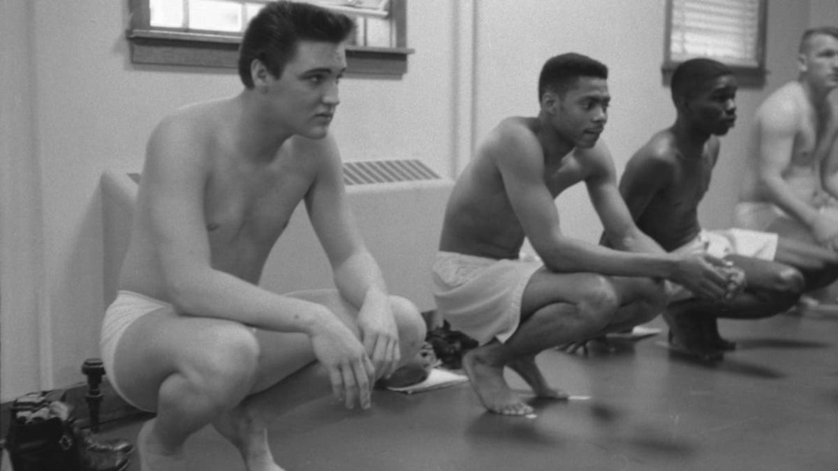 Elvis Presley squats while waiting for exams in the Army