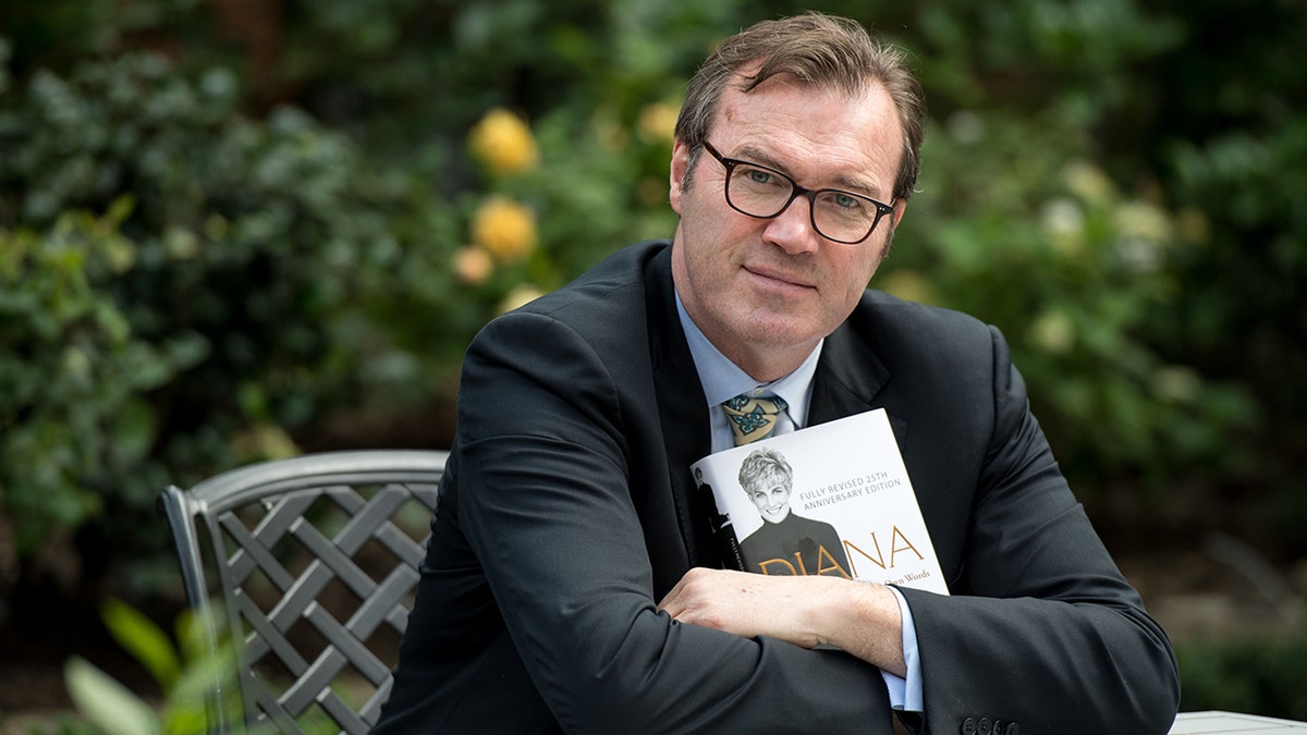 Andrew Morton posing with his book on Princess Diana