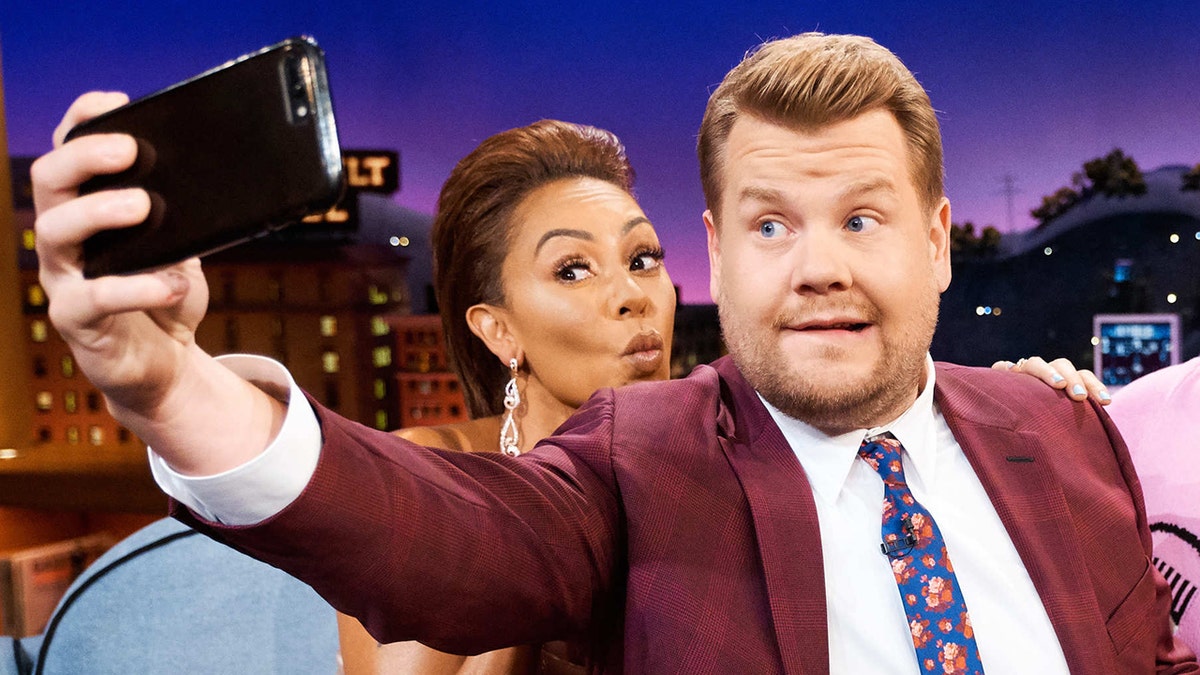 Mel B and James Corden on 'The Late Late Show' taking a selfie, James corden wears a red/purple suit