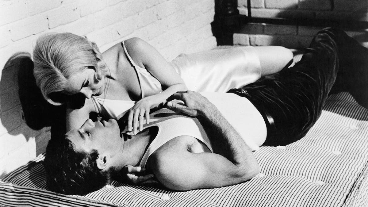 Yvette Mimieux and Richard Chamberlain lie together on a mattress