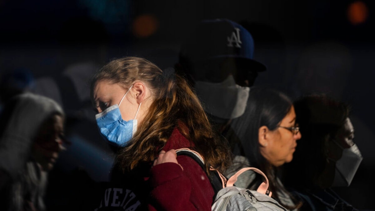 Holiday travelers wear masks