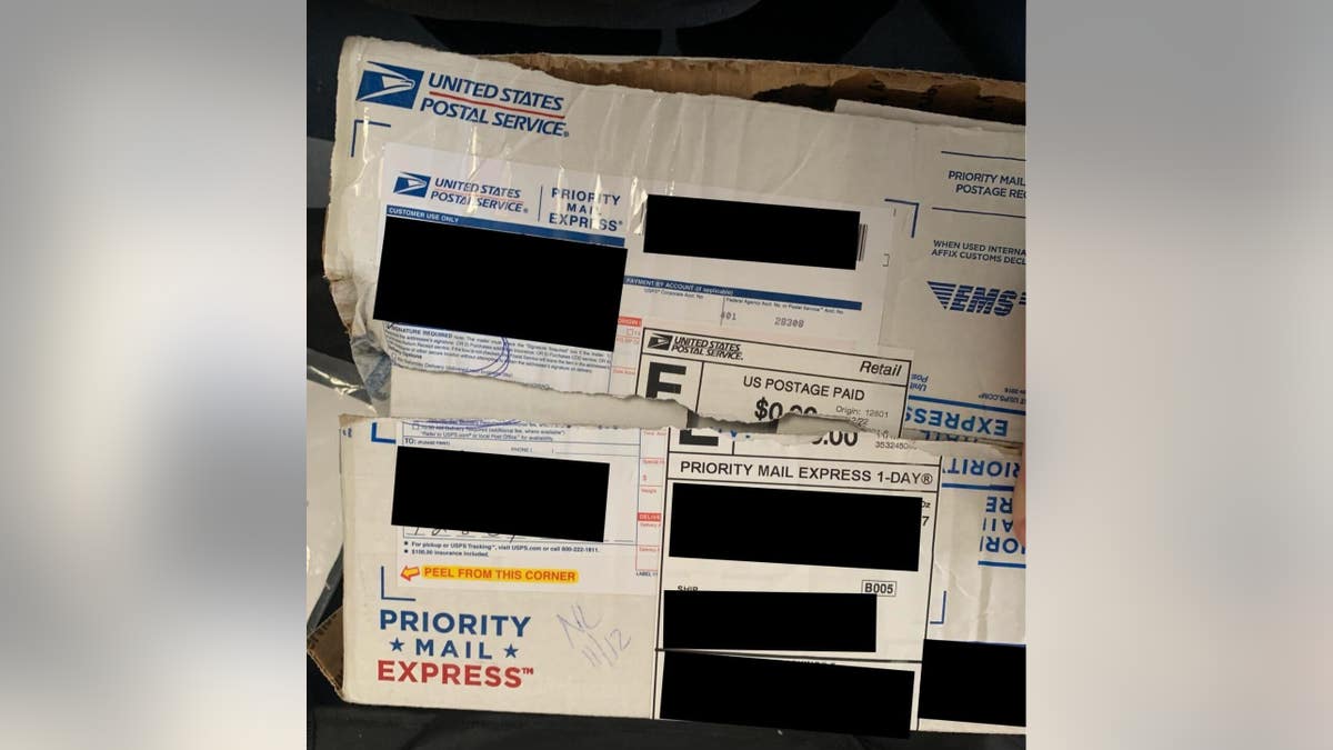 Photos of ripped packages containing donor checks allegedly stolen by U.S. Postal Service workers.