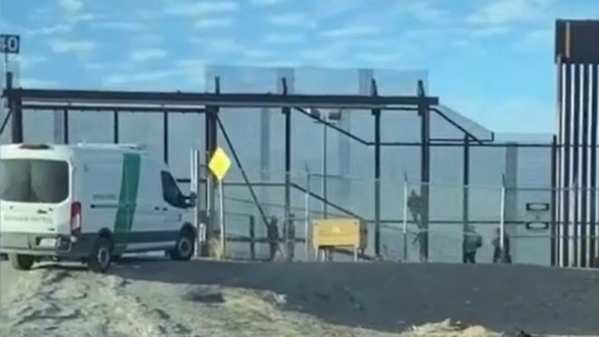Immigrants cross border fence in El Paso, Texas