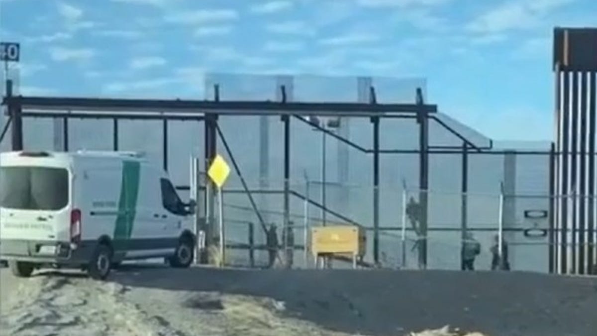 Immigrants cross border fence in El Paso, Texas