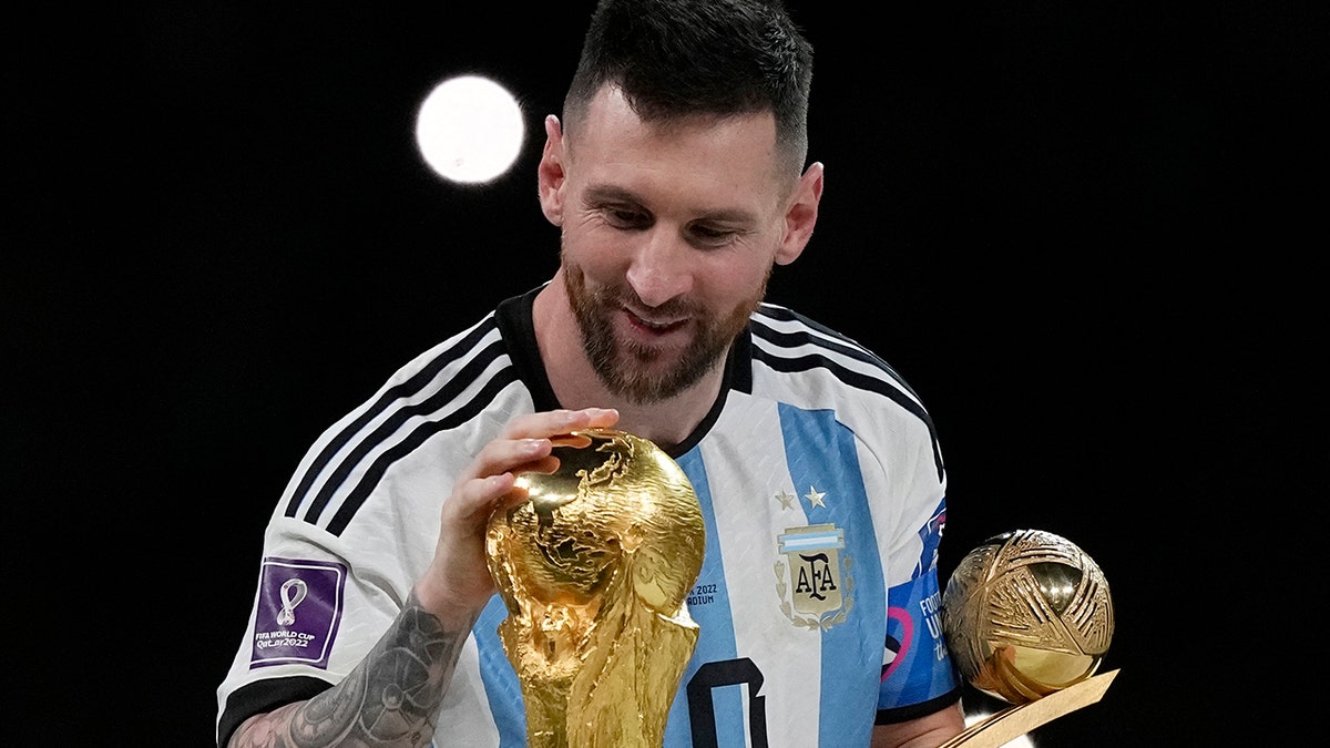 Lionel Messi pats the trophy