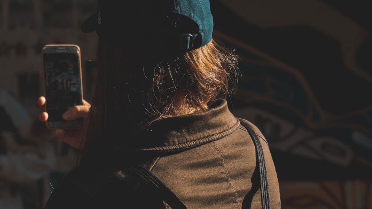 Photo of a person outdoors with a jacket and a teal cap.