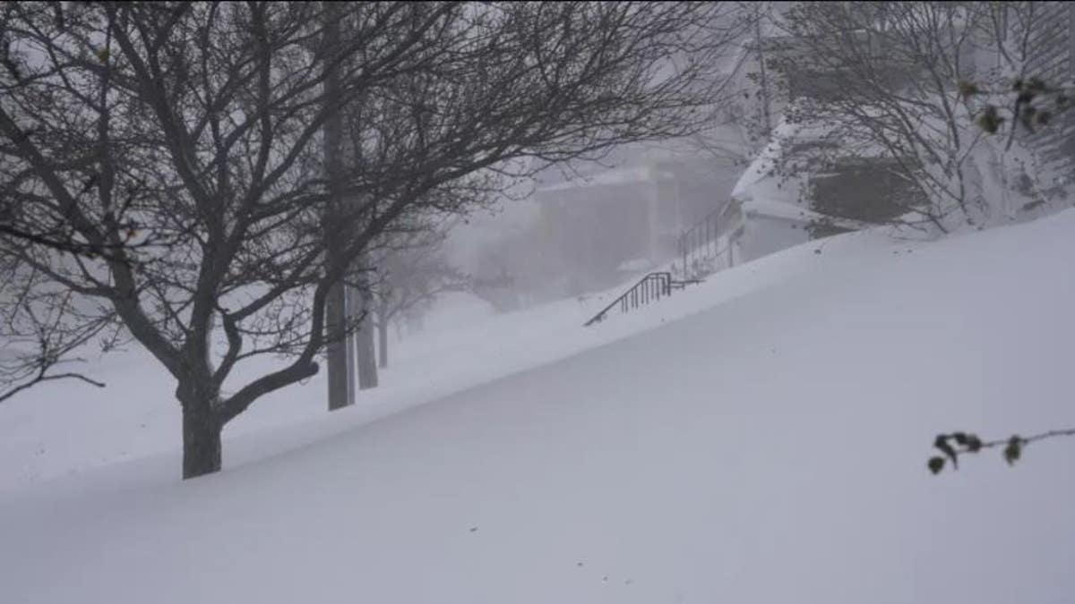 Snow drifts over the sidewalk on West Delavan Avenue in Buffalo, N.Y.