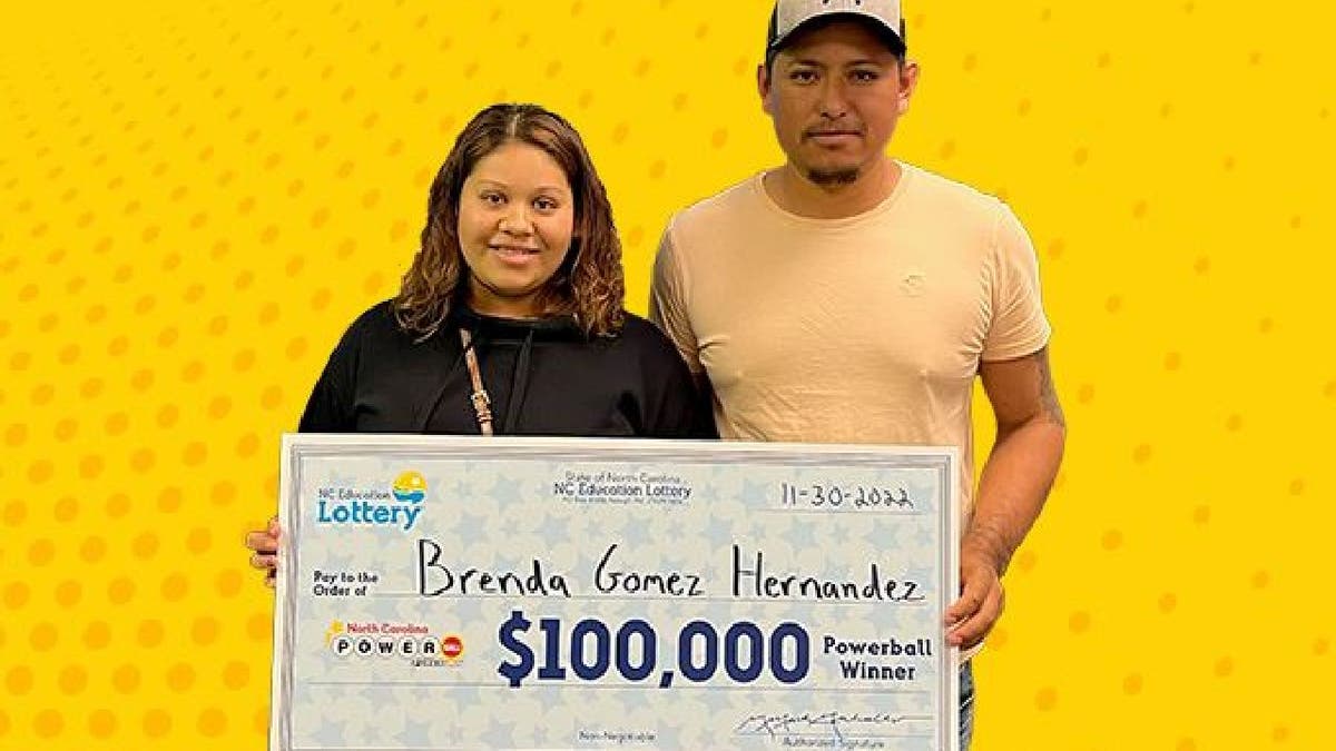 Lottery winner Brenda Gomez Hernandez hold winning check with unnamed man