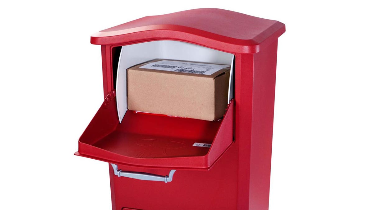 Red mailbox with package inside in front of a white background.