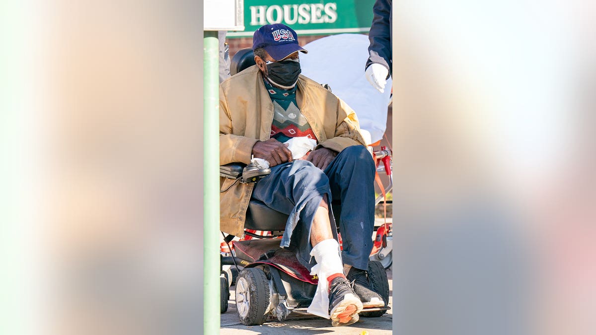 Man in wheelchair with bandaged ankle