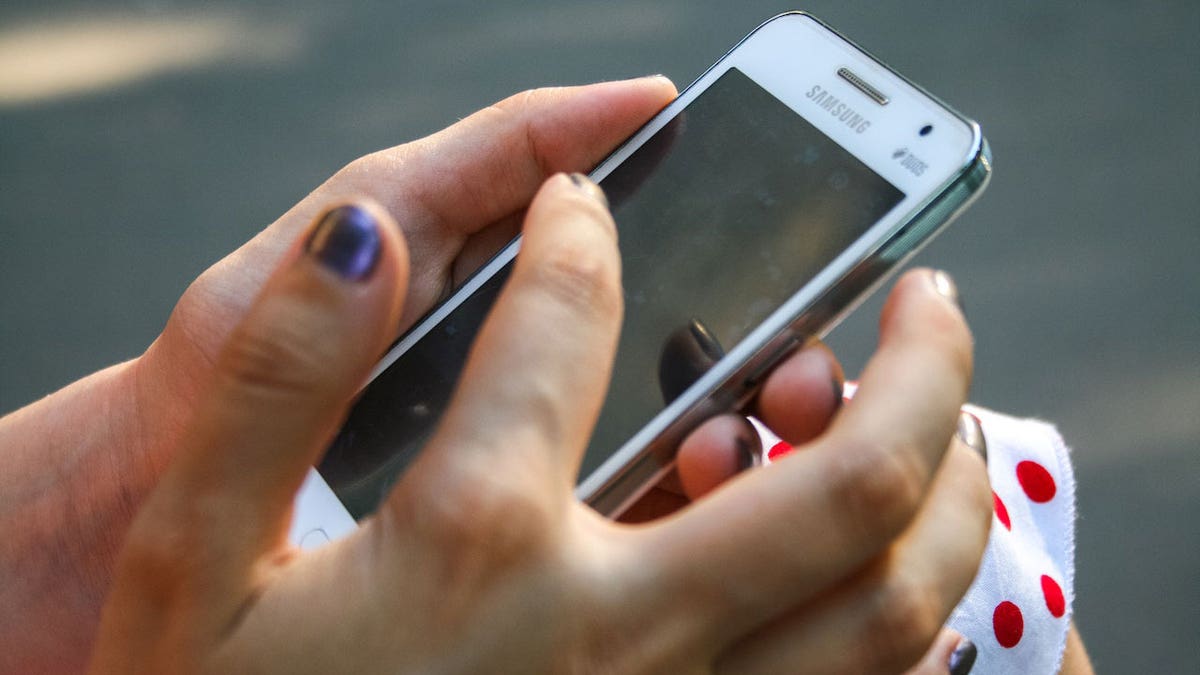 Woman using a white smartphone.