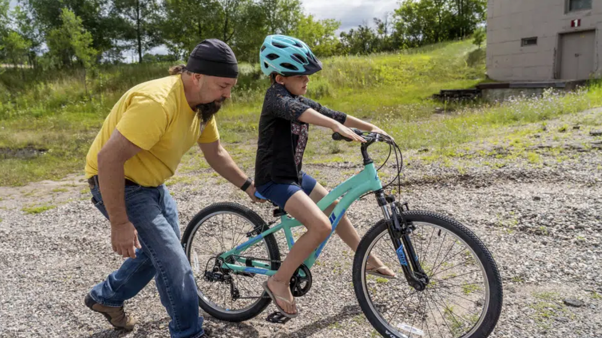 Steven Pringle helping child ride bike