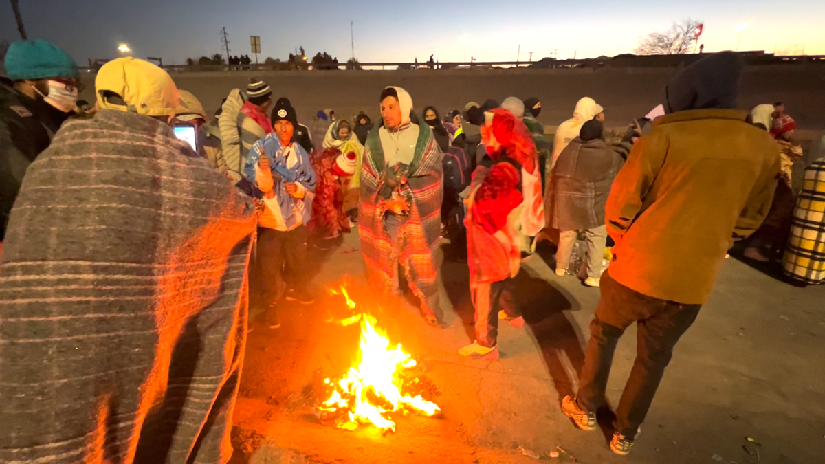 Migrants warming up by a fire
