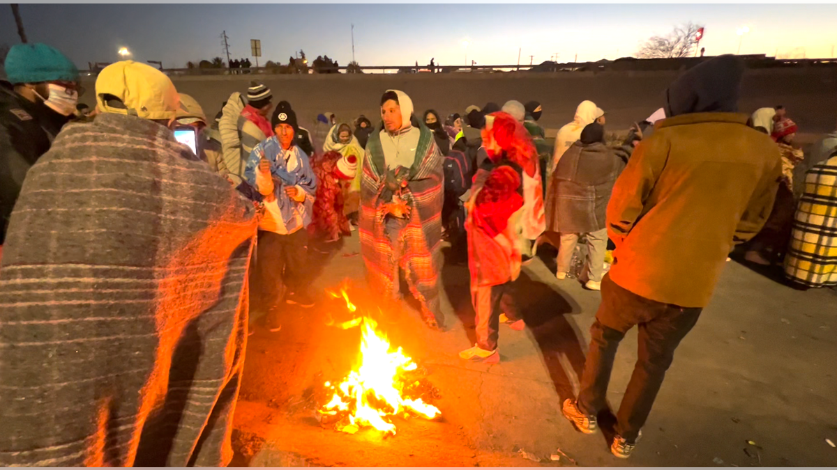 Migrants warming up by a fire