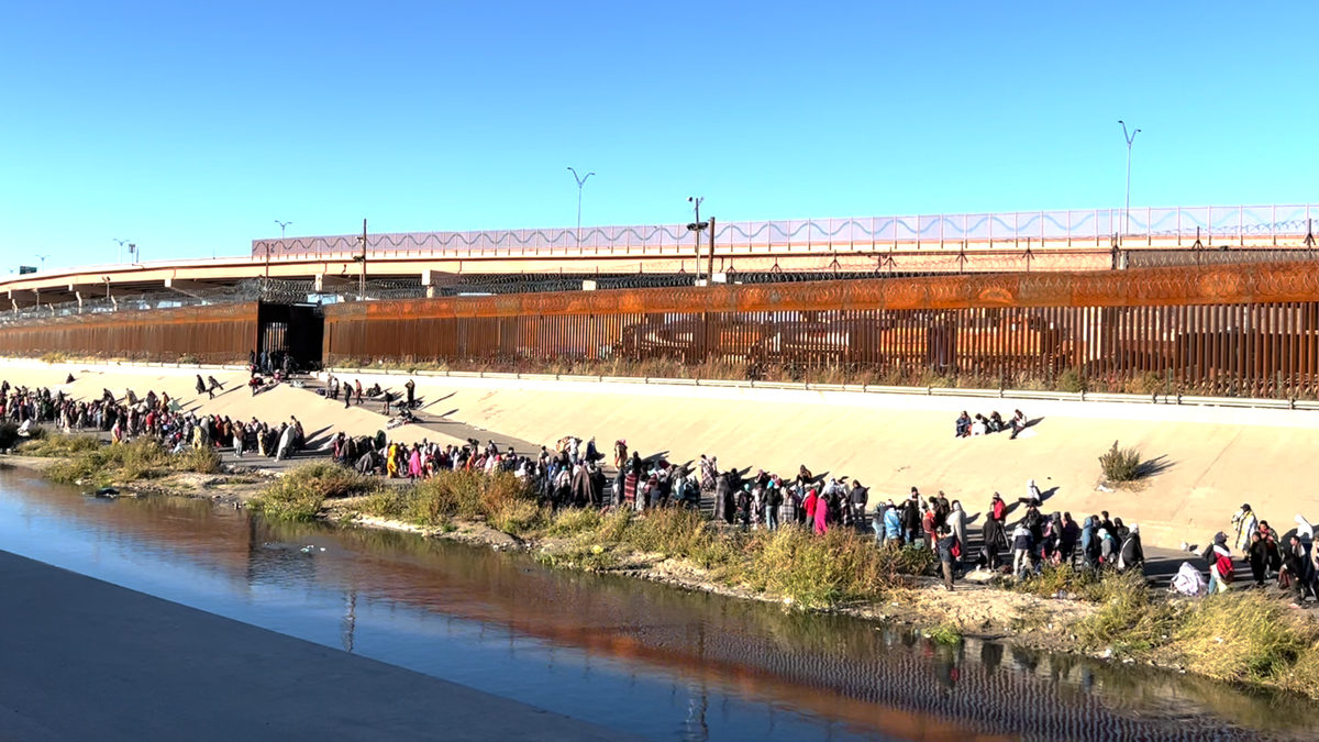 Migrants in line by the Rio Grande