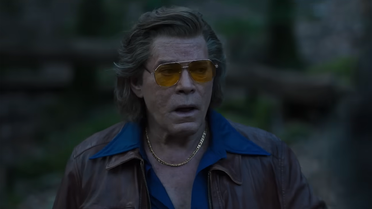 Ray Liotta's character wears a brown jacket and blue collared shirt with yellow-tinted aviators in "Cocaine Bear"