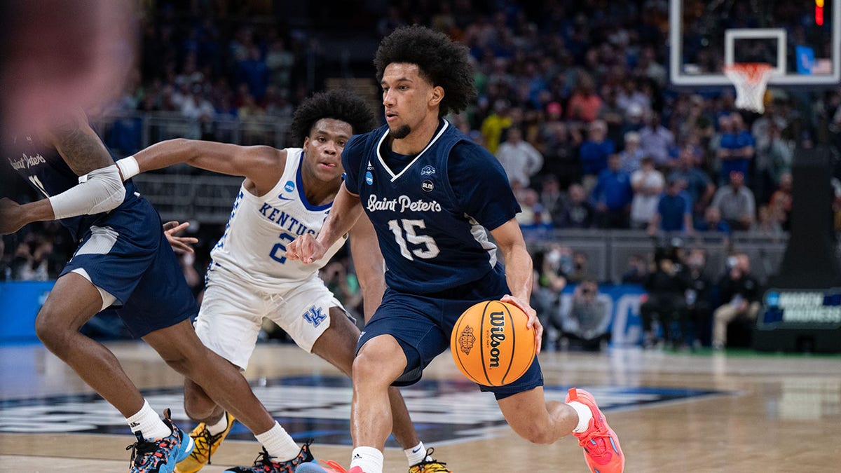 Saint Peter's player drives past a Kentucky player