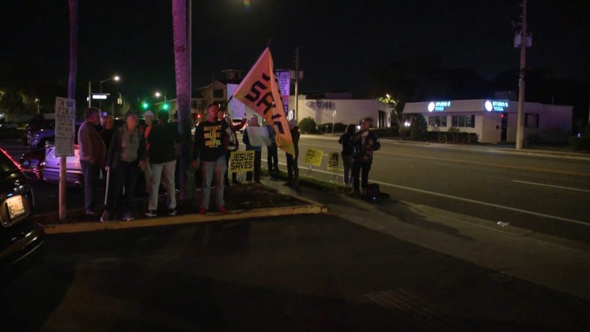 Protesters hold "Jesus Saves" signs