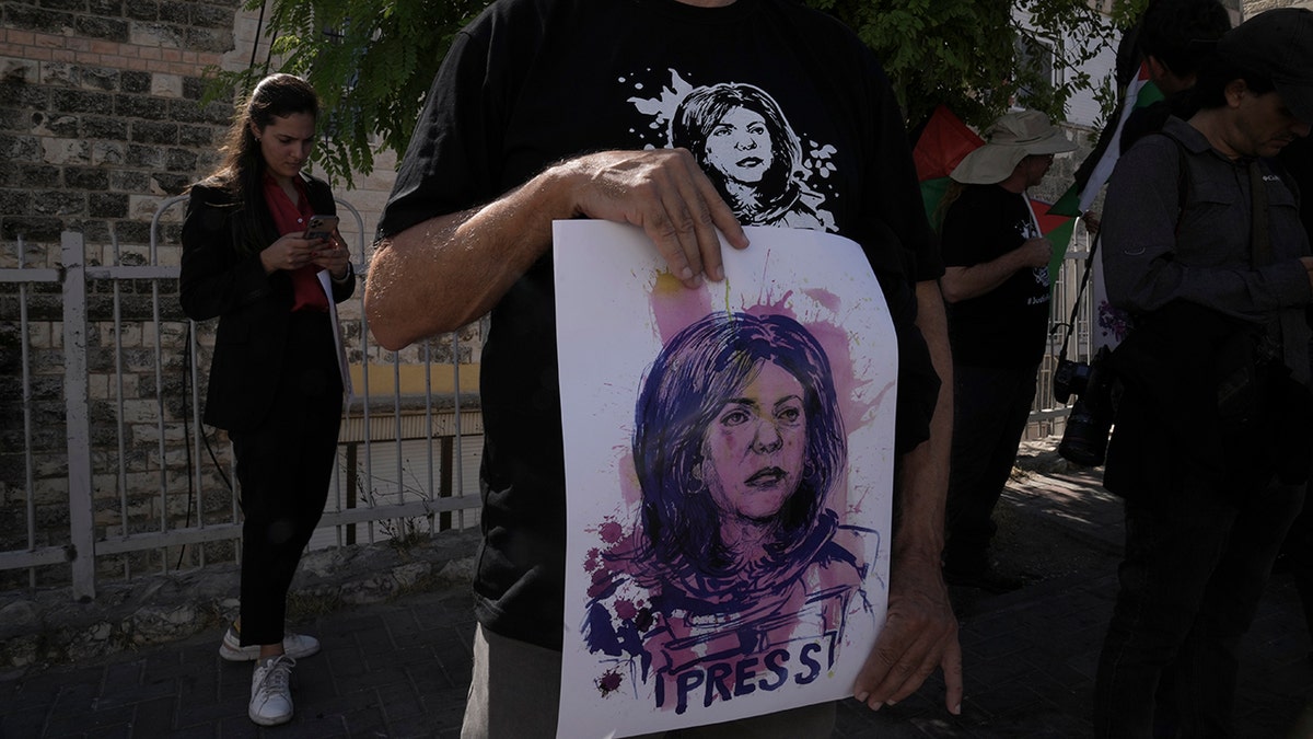 Protestor holding up sign of slain journalist Shireen Abu Akleh
