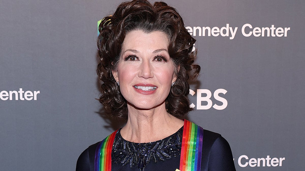 Amy Grant smiles with rainbow ribbons