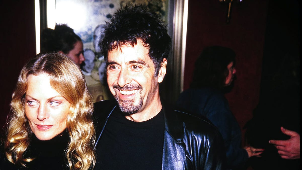 Beverly D'Angelo and Al Pacino walk arm in arm together at a film premiere