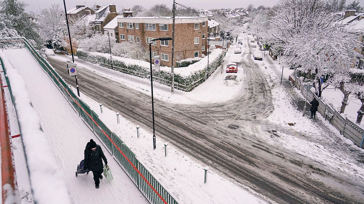 Snow covers railroad tracks, streets and buildings during heavy snow in England