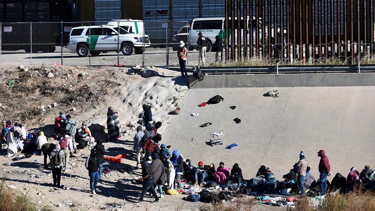 Migrants wait to cross the U.S.-Mexico border
