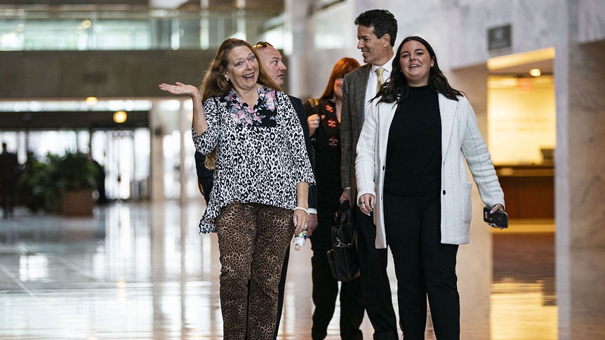 Carole Baskin wears cheetah print pants and top as she walks through Capitol Hill