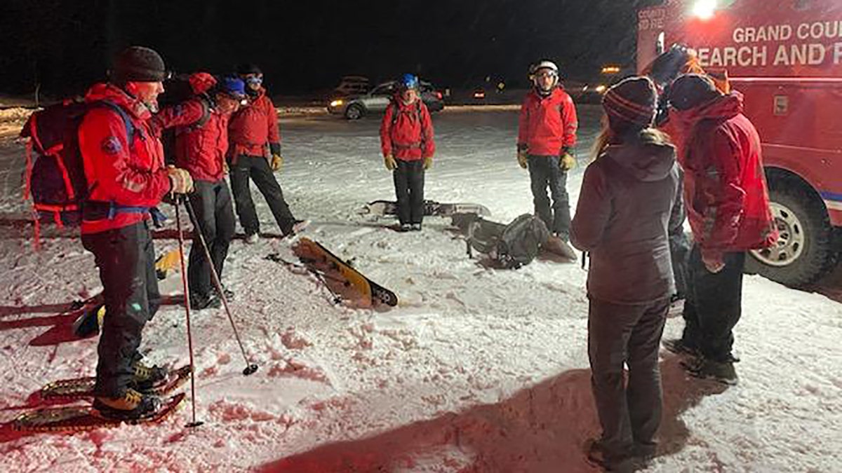 rescuers standing in snow