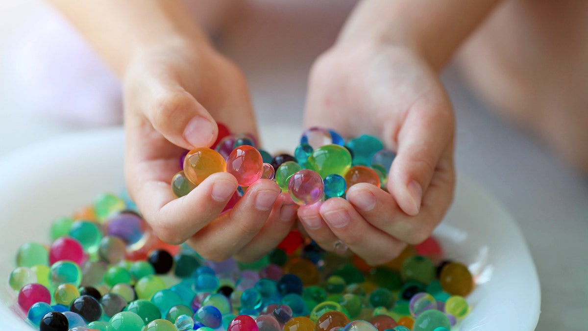 child's hands with water beads