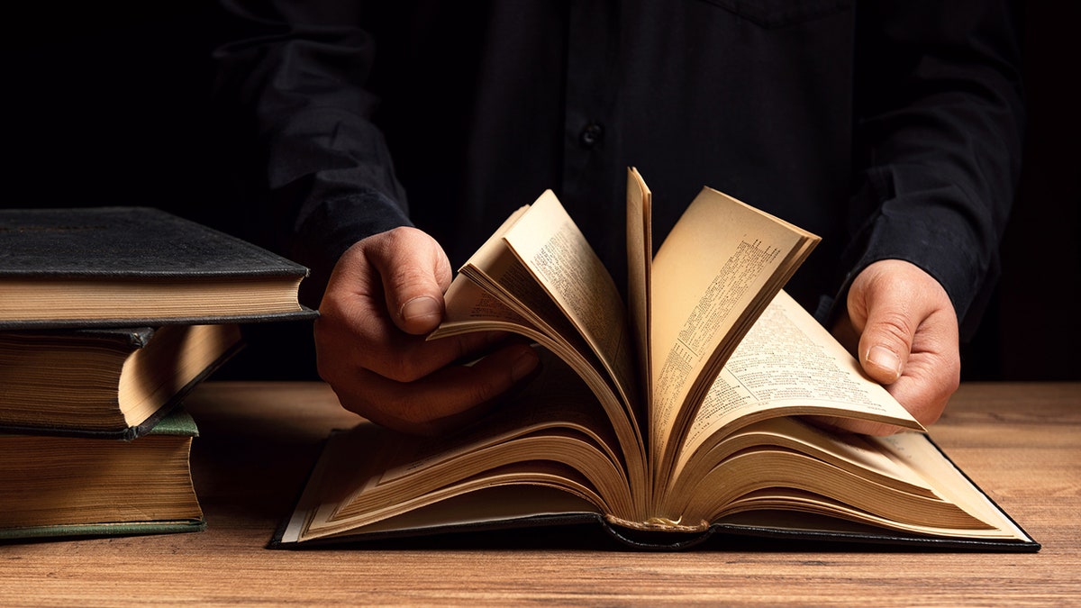 man flipping through Bible