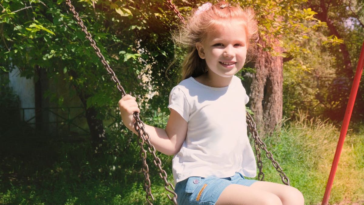 Girl sits on swing