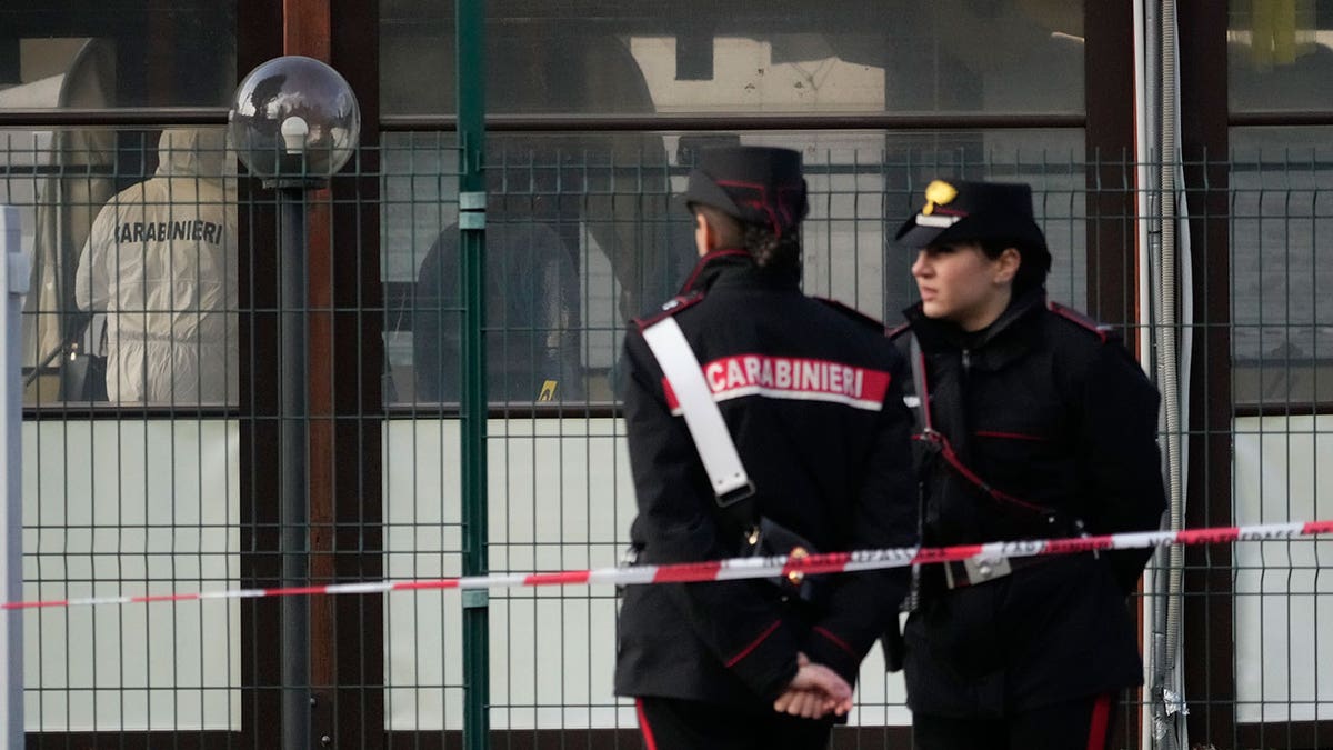 Italian police stand out front of a bar following a shooting