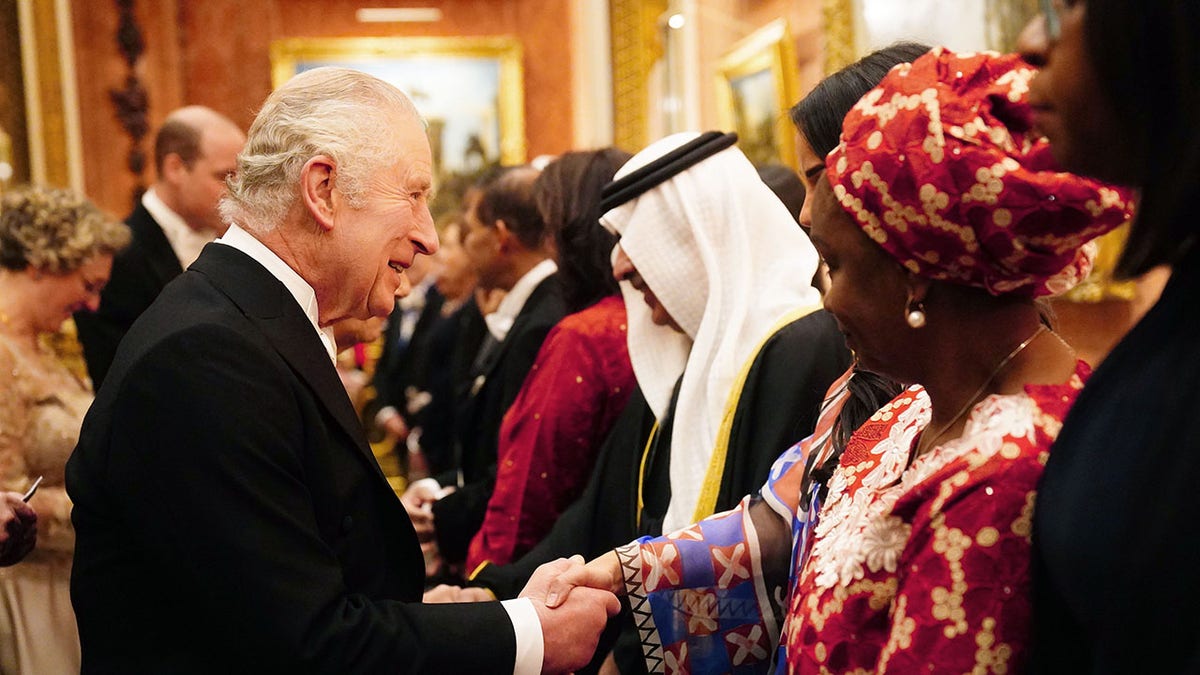 King Charles shaking hands with a guest.