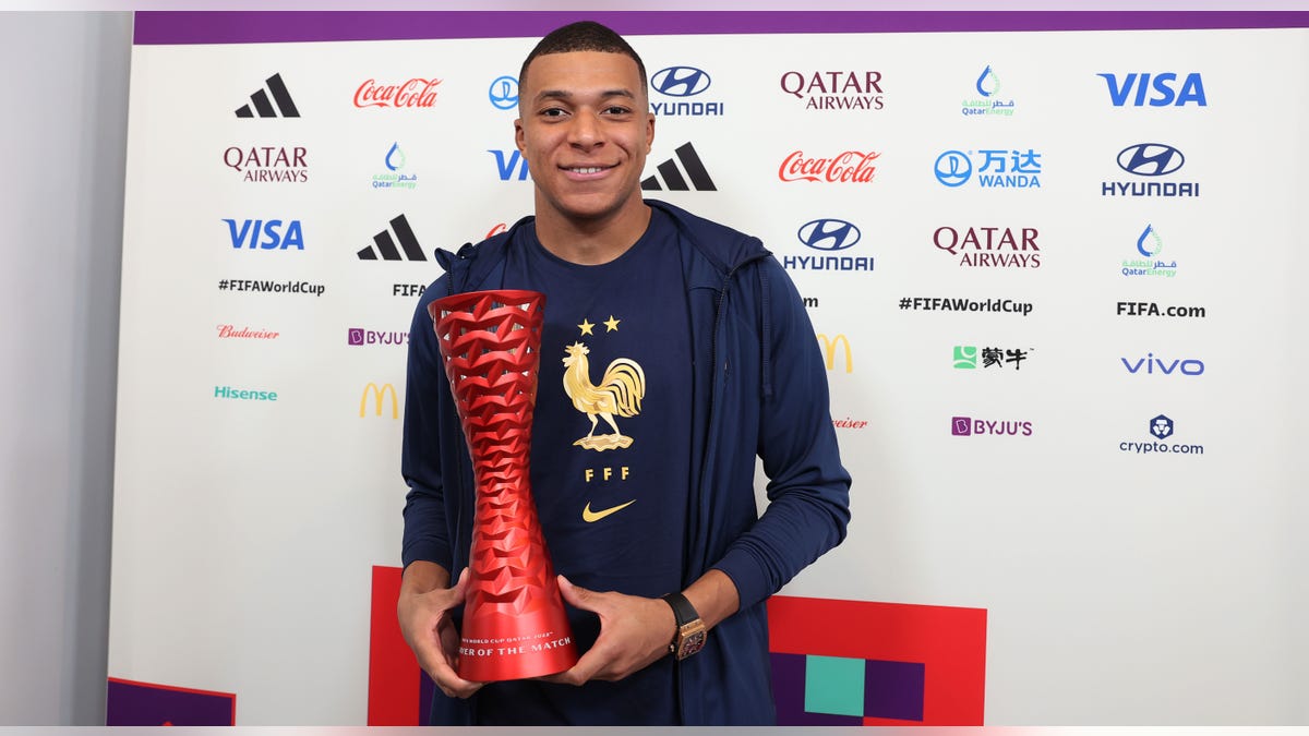 Kylian Mbappe poses with man of the match award