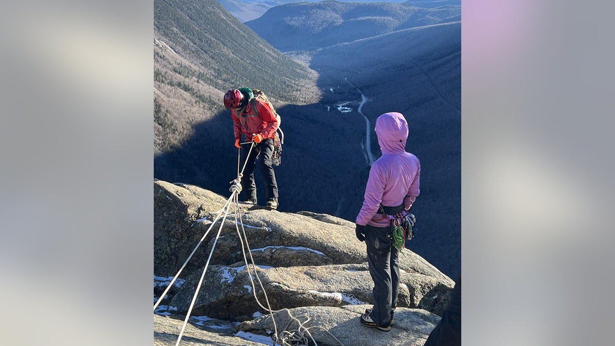 rescuers rappelling down cliff