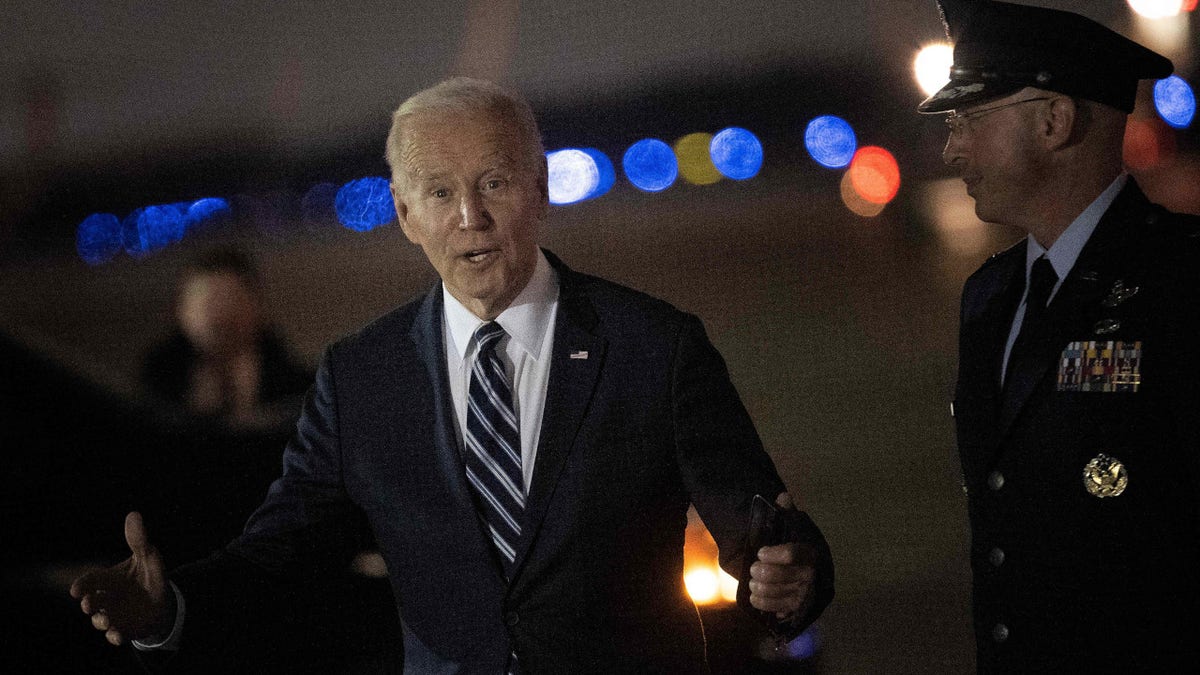 President Joe Biden answers reporters' questions after disembarking Air Force One