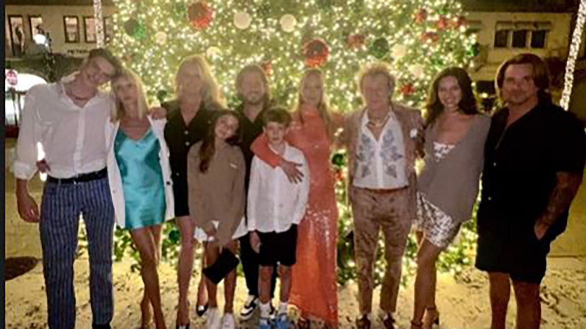 Rod Stewart with his wife and kids in front of a Christmas tree