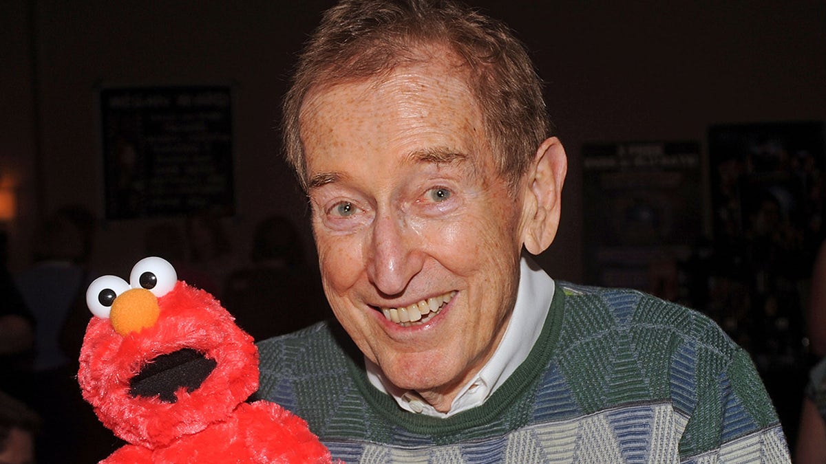 Bob McGrath and Elmo smile for cameras